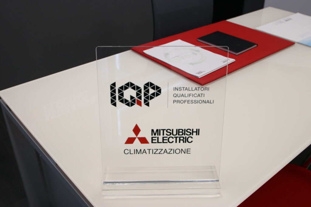 Targa Mitsubishi Electric su tavolo bianco.