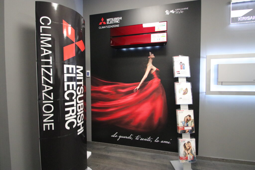 Esposizione climatizzatori Mitsubishi Electric con pannello pubblicitario.