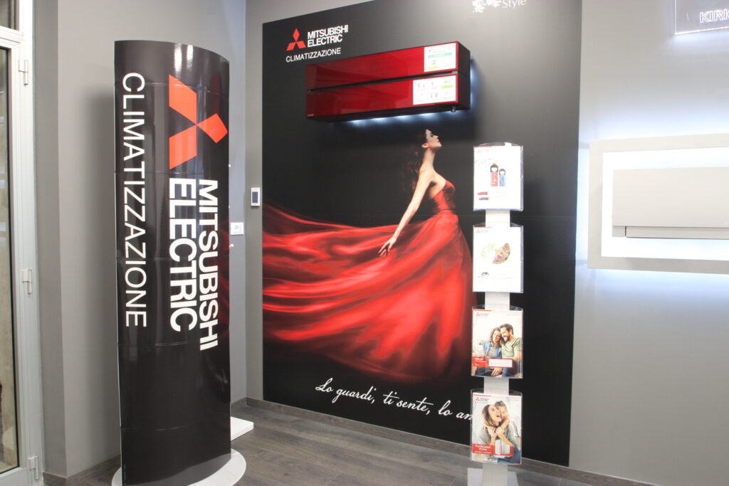 Esposizione climatizzatori Mitsubishi Electric con pannello pubblicitario.