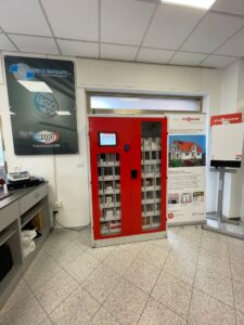 Armadio rosso con cassetti, poster e bancone ufficio.