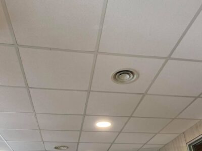 Soffitto con pannelli quadrati e luci incassate.