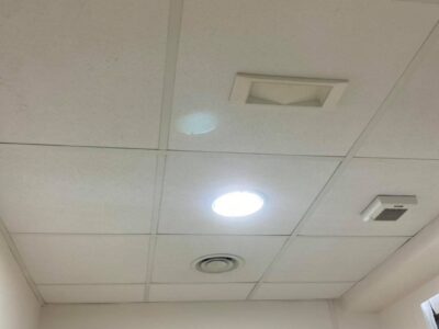 Soffitto con pannelli, luce e bocchetta di ventilazione.