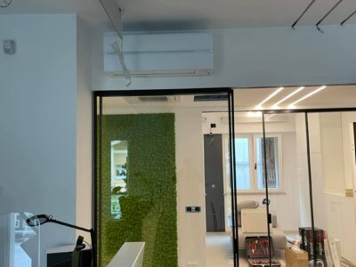 Ufficio moderno con parete verde e vetrate trasparenti.