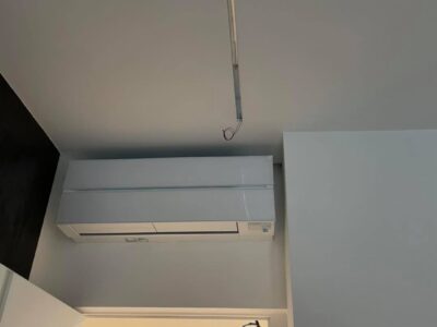 Condizionatore a parete e filo elettrico pendente.