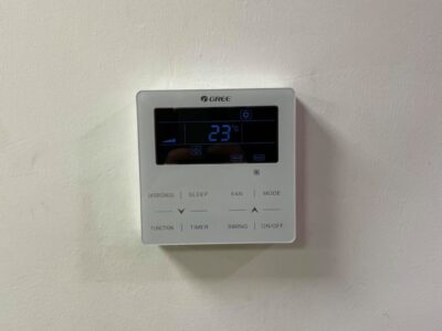 Termostato digitale montato su una parete bianca.