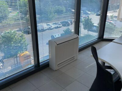 Condizionatore in ufficio con finestre e veneziane chiuse.