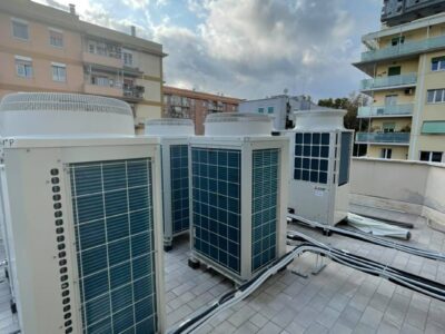 Unit&agrave; esterne di climatizzazione su un tetto, cielo nuvoloso.