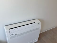 Condizionatore bianco a parete su pavimento in legno.