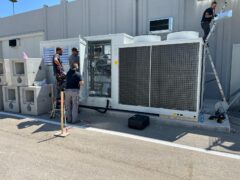 Tecnici lavorano su un'unit&agrave; di climatizzazione esterna.