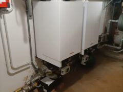 Caldaie bianche installate in un locale tecnico.