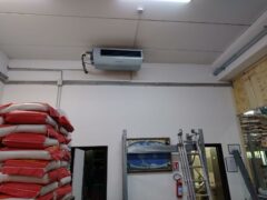 Interno di magazzino con condizionatore e sacchi impilati.
