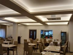 Ristorante elegante con tavoli apparecchiati e illuminazione soffusa.