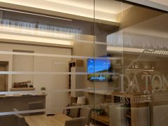 Interno di un ristorante con vetrata e televisore acceso.
