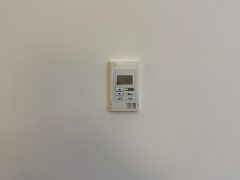 Termostato bianco montato su parete bianca.