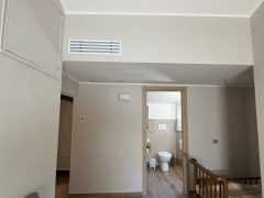 Camera con pavimento in legno, lettino e bagno.