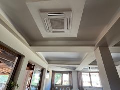 Sala da pranzo con tavoli apparecchiati e finestre luminose.