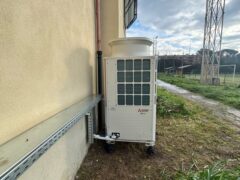 Unit&agrave; esterna di climatizzazione accanto a un edificio.