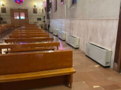 Interno di una chiesa con panche e vetrate colorate.