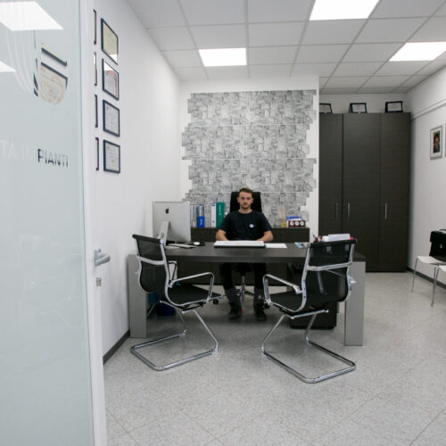 Uomo seduto alla scrivania in ufficio moderno.