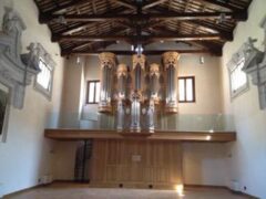 Interno con organo a canne e soffitto in legno.