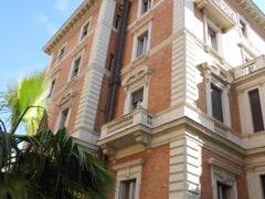 Edificio storico in mattoni con dettagli bianchi.