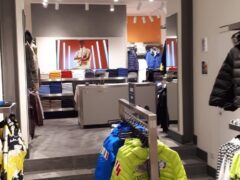 Negozio di abbigliamento con giacche colorate esposte.