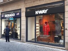 Vetrine dei negozi Sebago e K-Way su strada.