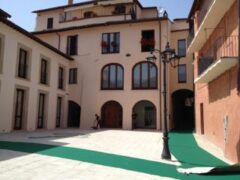 Edificio con cortile e lampione in una giornata soleggiata.