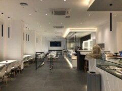 Interno di un ristorante moderno, con tavoli e bancone.