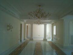 Interno elegante con lampadario e colonne bianche.