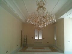 Stanza vuota con grande lampadario e scala.