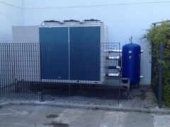 Unit&agrave; di condizionamento esterna recintata, con serbatoio blu.