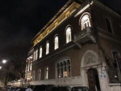 Edificio storico illuminato di notte, con finestre ad arco.