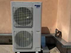 Unit&agrave; esterna di climatizzazione su pavimento in cemento.