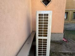 Unit&agrave; esterna di condizionamento accanto a un edificio.